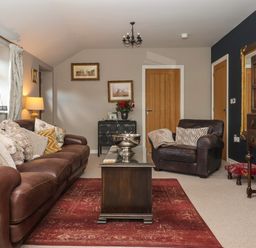 A living room with sofa and armchair at 1 Church Barns in Pocklington