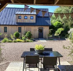An outdoor area with a table and chairs in front of a wooden building at Larchwood Lodge in Ellon