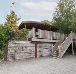 A wooden cabin with a deck and stairs at Sunny View in Rhayader