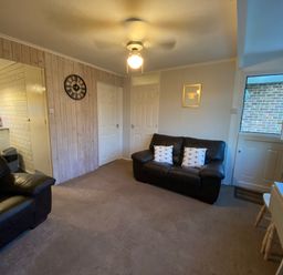 A living room with a sofa, armchair and clock at 246 California Road, California, Norfolk