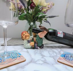 A dining table with wine glasses coasters and a figurine at Hidden Treasure Brixham