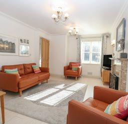 A living room with sofas, a coffee table, and a television at 5 Styleman Road in Hunstanton