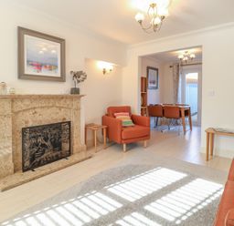 A living room with a fireplace and armchairs at 5 Styleman Road in Hunstanton