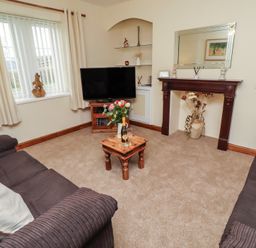 A living room with a television and a table at The Retreat in Embleton