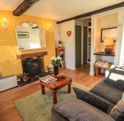 A living room with a fireplace and coffee table at Buttonhole Cottage in Ambleside