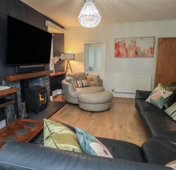A living room with a television and sofa at Newby Bridge House in Newby Bridge