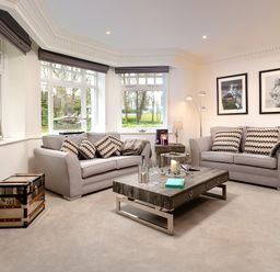 A living room with two sofas a coffee table and framed pictures on the wall at Skyfall in Bowness