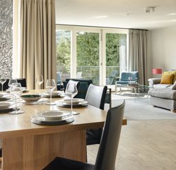 A dining area with a table set and a living room at Take Five in Ambleside