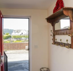 A hallway with a door and coat rack at Woodside West in Bowness