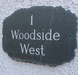 A property sign with number and name at Woodside West in Bowness