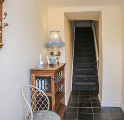 A hallway with a table and lamp at Woodside West in Bowness