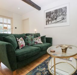 A living room with a sofa and coffee table at Corner Cottage in Troutbeck
