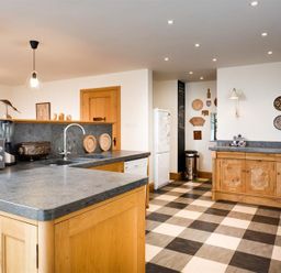 A kitchen with checkered floor wooden cabinets and various appliances at The Old Coach House in Troutbeck