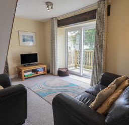 A living room with a television and sliding doors at A River Runs By in Staveley