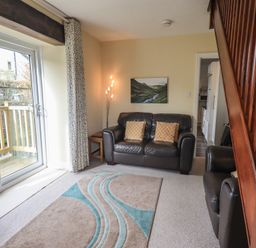 A living room with a sofa and armchair at A River Runs By in Staveley
