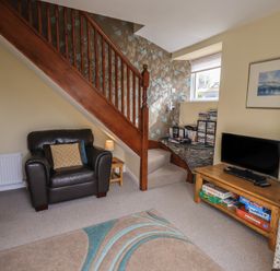 A living room with a sofa and television at A River Runs By in Staveley