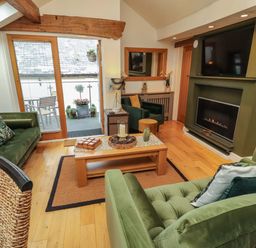 A living room with a sofa and fireplace at Workshop Cottage in Bowness