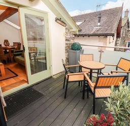 A balcony with a table and chairs at Workshop Cottage in Bowness