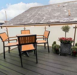 A balcony with a table and chairs at Workshop Cottage in Bowness
