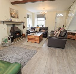 A living room with a fireplace and sofas at Smithy Cottage at Bowland Bridge Bowness