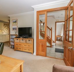 A living room with a sofa, coffee table, and TV at Middlerigg in Troutbeck