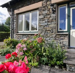 An outdoor area with flowers and stone wall at Middlerigg in Troutbeck