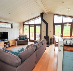 A living room with a television and stove at The Loghey in Hawkshead
