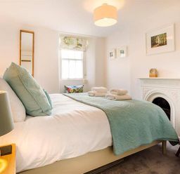 A bedroom with a bed and folded towels near a fireplace at Lettera in Ambleside