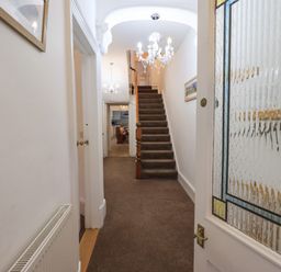 A hallway with carpeted stairs and chandeliers at Number Twenty in Keswick