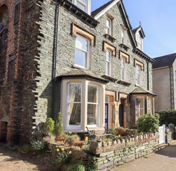 Exterior view of a stone house with bay windows and a small garden at Number Twenty in Keswick