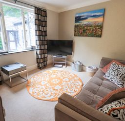 A living room with a couch and television at Ghyll Heights in Ambleside