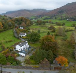 A house surrounded by fields and trees at Goody Raise in Grasmere