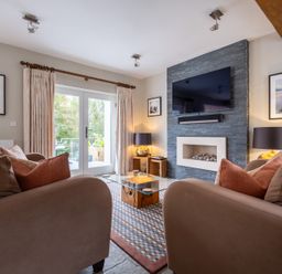 A living room with a television, sofa and coffee table at Goody Raise in Grasmere