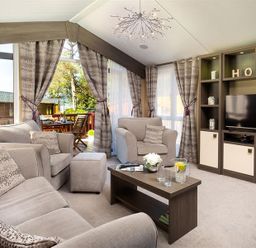 A living room with a sofa armchairs coffee table and television at Lancashire Rose in Ambleside