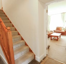A hallway with stairs and a view of the living room at Hawkshead Hall in Hawkshead