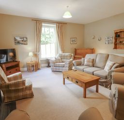 A living room with a sofa and armchairs at Hawkshead Hall in Hawkshead