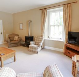 A living room with a sofa and armchair at Hawkshead Hall in Hawkshead