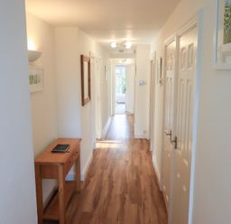 A hallway with wood flooring and a console table at Mardale in Ambleside