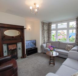 A living room with sofas a wooden coffee table and a fireplace at Fell End in Keswick