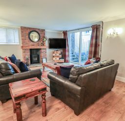 A living room with a sofa and television at Chapel Hill Cottage in Ambleside