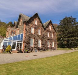 A house exterior with a conservatory and garden at South View in Keswick