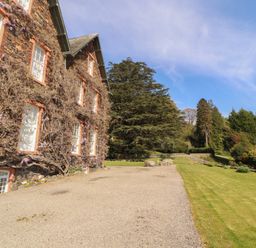 A garden area with a house and trees at South View in Keswick