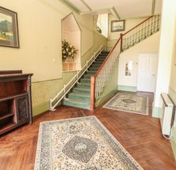 A hallway with a staircase and sideboard at South View in Keswick