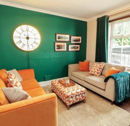 A living room with a clock and sofa at Gildabrook Cottage in Bowness