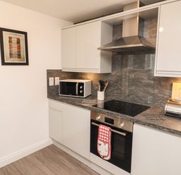 A kitchen with microwave oven stovetop and bread box at Kirkstones in Keswick