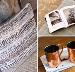 Close up of cushions an open book with black and white photos and two copper mugs on a tray at High Cunsey Farm Far Sawrey