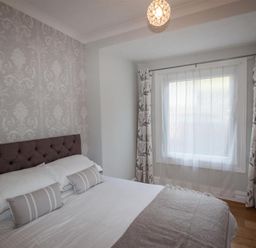 A bedroom with a bed pillows and a window with curtains at Waterside in Ambleside