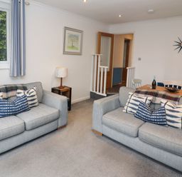 A living room with two grey sofas and blue patterned cushions at Helm Crag in Grasmere