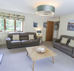A living room with a sofa, coffee table, and lamp at No 7 in Ambleside