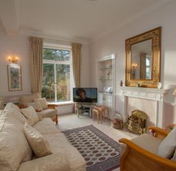 A living room with sofas a fireplace a mirror and a television at Betamere in Ambleside
